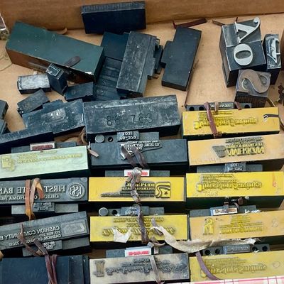 Sale Photo Thumbnail #93: Assortment of vintage printing blocks, metal type, and wooden stamps, showing signs of age and use.