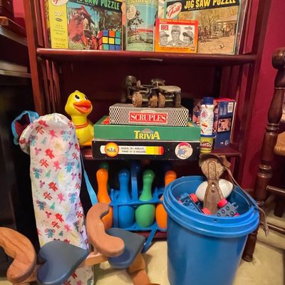 Sale Photo Thumbnail #213: Collection of vintage toys and board games, including Guild jigsaw puzzles, Scruples, Trivia, a plastic bowling set, and a wooden riding toy.