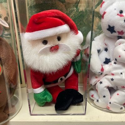 Sale Photo Thumbnail #184: Ty Beanie Baby "1997 Teddy" Santa Claus plush toy, displayed inside a protective clear acrylic case alongside other collectible plush bears.