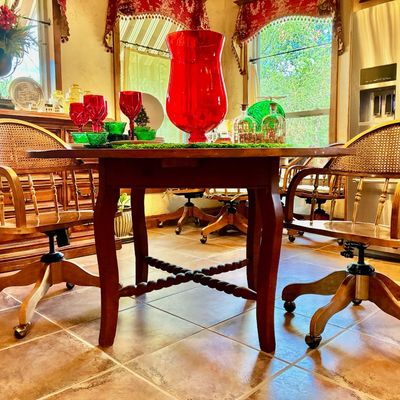 Sale Photo Thumbnail #197: Vintage wooden dining table with barley twist stretchers, paired with rolling wooden armchairs featuring woven cane backs.