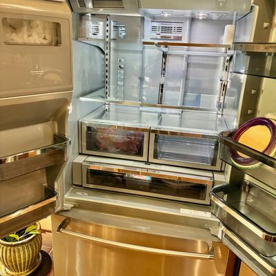 Sale Photo Thumbnail #62: Modern KitchenAid stainless steel French door refrigerator with bottom freezer, shown open to display the clean interior shelving and drawers.