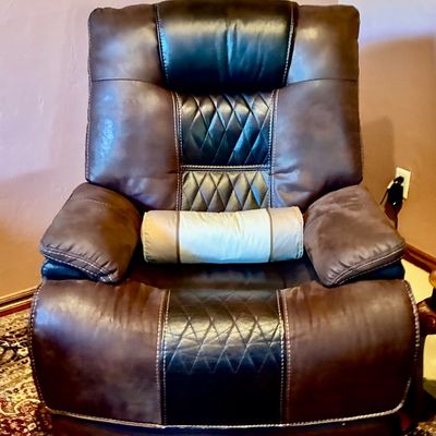 Sale Photo Thumbnail #13: Contemporary brown faux-leather recliner featuring diamond-quilted black accents, contrast stitching, and a matching bolster pillow.