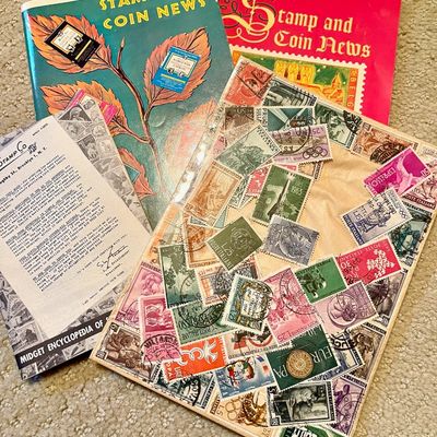 Sale Photo Thumbnail #217: Vintage stamp collecting ephemera, including issues of "Stamp and Coin News" magazines, a "Midget Encyclopedia of Stamps" booklet, and a decorative collage of international postage stamps.