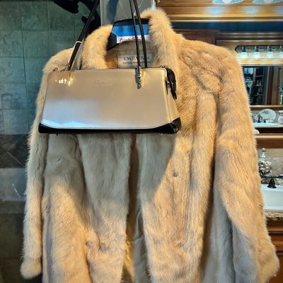 Sale Photo Thumbnail #55: Vintage EMBA Pearl natural pale beige mink fur jacket paired with a metallic silver and black patent leather handbag.