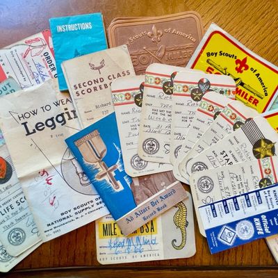 Sale Photo Thumbnail #225: Collection of vintage Boy Scouts of America memorabilia, including merit badge cards, scorebooks, and instructional pamphlets from the mid-20th century.