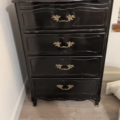 Sale Photo Thumbnail #29: French Provincial style four-drawer chest of drawers, painted in a glossy black finish with ornate gold-toned hardware.