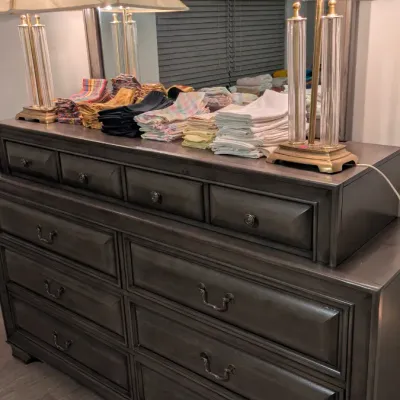 Sale Photo Thumbnail #25: Contemporary dark gray wooden dresser with matching wall mirror, featuring a tiered drawer design and traditional metal hardware.