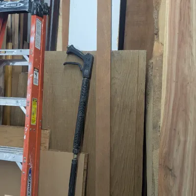 Sale Photo Thumbnail #65: Assorted lumber, plywood sheets, and live-edge wood planks stored vertically alongside a Werner stepladder and a pressure washer spray wand.