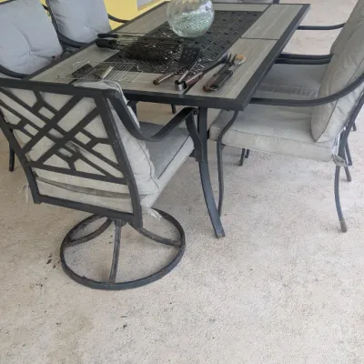 Sale Photo Thumbnail #69: Outdoor dining set featuring a rectangular metal-framed table with a tiled top and six matching cushioned armchairs, including two swivel chairs.