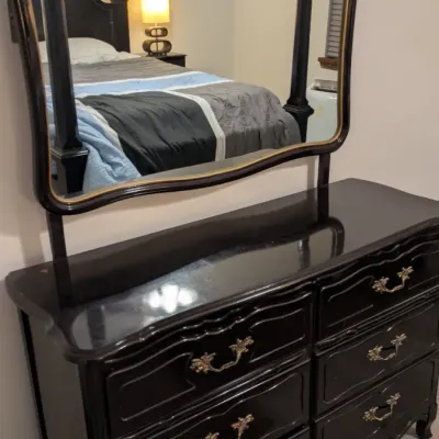 Sale Photo Thumbnail #31: French Provincial style six-drawer dresser in a black lacquered finish, featuring ornate brass pulls and a matching attached mirror with gold accents.