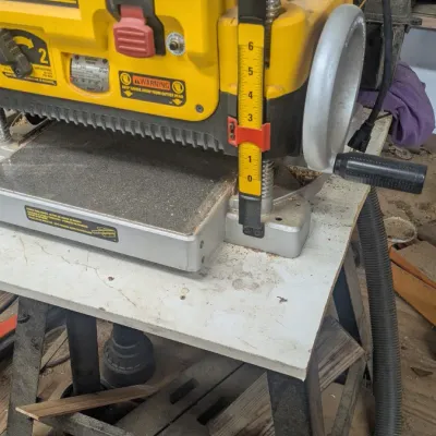 Sale Photo Thumbnail #52: DeWalt portable thickness planer mounted on a mobile work stand, showing signs of moderate workshop use.