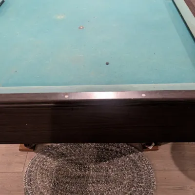Sale Photo Thumbnail #41: Vintage pool table with a green felt surface, dark wood frame, and accompanying billiard balls and racks.