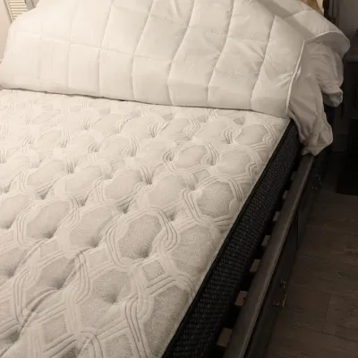 Sale Photo Thumbnail #91: Contemporary dark gray wooden sleigh bed frame with built-in under-bed storage drawers, shown with a quilted mattress and bedding.