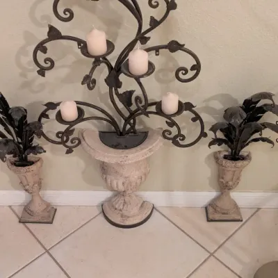 Sale Photo Thumbnail #93: Wrought iron tree-style candelabra set in a distressed stone-look urn, flanked by two matching small urns with metal foliage inserts.
