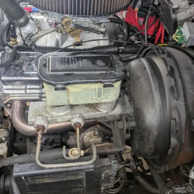 Sale Photo Thumbnail #58: Under-hood view of a vehicle engine bay, featuring a chrome air cleaner, brake master cylinder, and power brake booster.