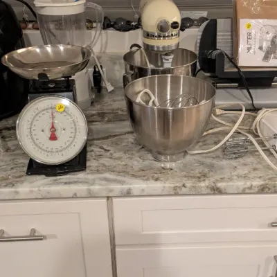 Sale Photo Thumbnail #90: Assorted kitchen appliances including a cream-colored KitchenAid stand mixer with extra bowl and attachments, a vintage-style kitchen scale, and a blender.