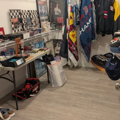 Sale Photo Thumbnail #73: Collection of NASCAR memorabilia, including Dale Earnhardt posters, jackets, collectible cereal boxes, and die-cast cars displayed in a closet.