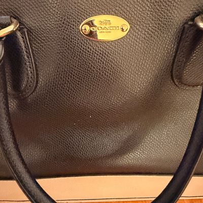 Sale Photo Thumbnail #28: Coach pebbled leather handbag in black and cream, featuring a gold-tone logo plaque and dual rolled top handles.