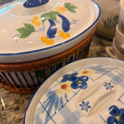 Sale Photo Thumbnail #137: Vintage ceramic covered casserole dishes with hand-painted floral motifs, including one nested in a woven rattan holder.