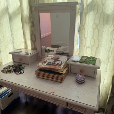 Sale Photo Thumbnail #102: White painted wooden vanity table with an attached mirror and two small side drawers, showing some surface wear and distressing.