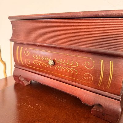 Sale Photo Thumbnail #46: Vintage wooden jewelry box designed to look like a stack of books, featuring gold-painted accents, a small metal drawer pull, and bracket feet.