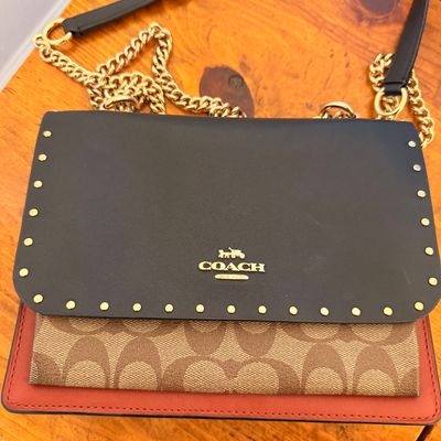 Sale Photo Thumbnail #31: Coach shoulder bag featuring a black leather flap with gold-tone stud detailing, signature canvas body, red leather trim, and a gold-tone chain strap.