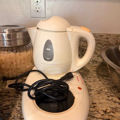 Sale Photo Thumbnail #139: Vintage Tefal Spirit of Tea electric kettle and heating base, featuring a white plastic body with orange accents.