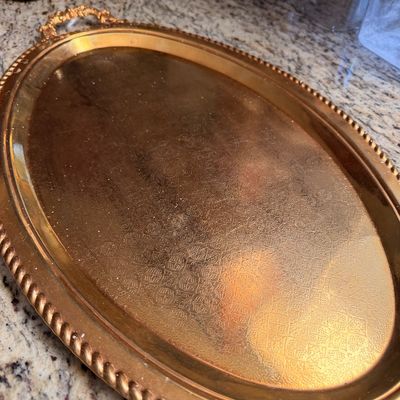 Sale Photo Thumbnail #81: Vintage oval brass serving tray featuring an etched floral pattern, a rope-twist border, and ornate handles.