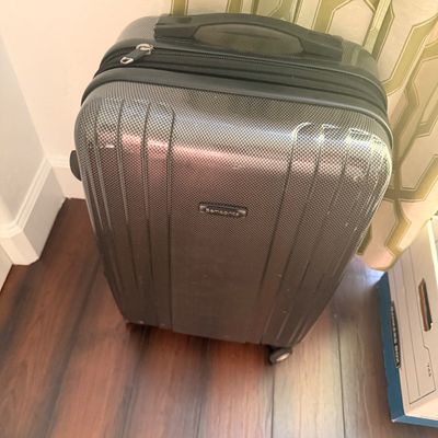 Sale Photo Thumbnail #100: Samsonite hardside spinner suitcase in a textured charcoal gray finish, showing minor surface wear.