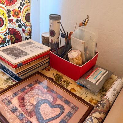 Sale Photo Thumbnail #114: Assorted craft supplies, including a framed "Love is Homemade" print, a stack of art books, and a red organizer box filled with paintbrushes and tools.