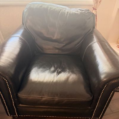 Sale Photo Thumbnail #90: Dark brown leather armchair featuring rolled arms with brass nailhead trim and a plush back cushion.