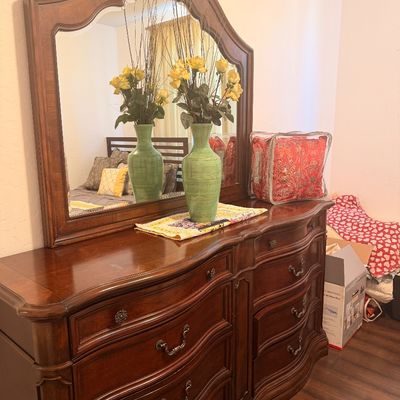 Sale Photo Thumbnail #118: Traditional dark wood double dresser featuring a serpentine front, ornate metal drawer pulls, and a matching arched mirror.