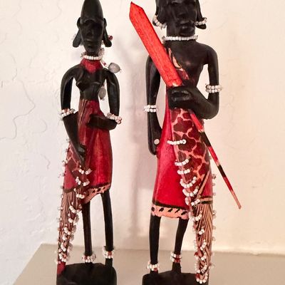 Sale Photo Thumbnail #16: Pair of hand-carved African Maasai tribal figures, featuring dark wood construction with red painted garments, beaded jewelry, and traditional details.