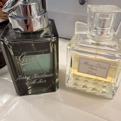 Sale Photo Thumbnail #84: Gucci by Gucci Pour Homme eau de toilette with a "Merry Christmas With love" inscription, alongside a bottle of Miss Dior Chérie L'eau eau de toilette.