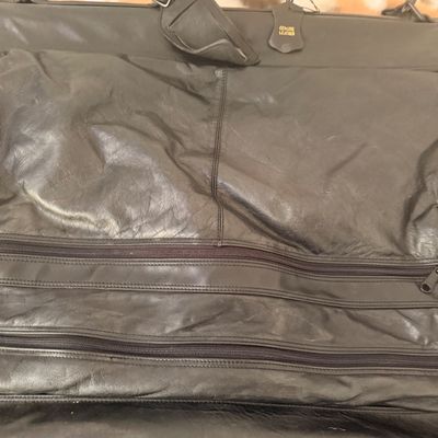 Sale Photo Thumbnail #105: Vintage black genuine leather garment bag featuring multiple zippered compartments, a sturdy carrying handle, and a shoulder strap.