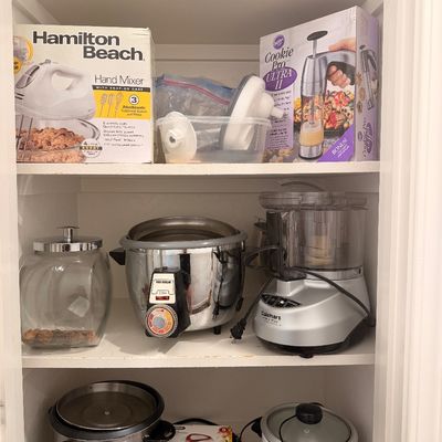 Sale Photo Thumbnail #99: Assorted kitchen appliances on pantry shelves, including a Hamilton Beach hand mixer, a Cuisinart food processor, and multiple rice cookers.