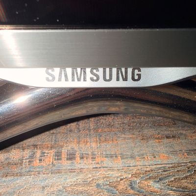Sale Photo Thumbnail #42: Close-up of a Samsung television bezel and stand, showing the brand logo on a silver trim.