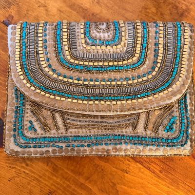 Sale Photo Thumbnail #26: Bohemian-style beaded clutch purse featuring intricate patterns of turquoise, gold, and silver beads on a neutral fabric background.