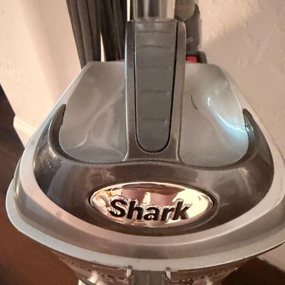 Sale Photo Thumbnail #50: Shark upright vacuum cleaner, showing the top handle and brand logo.