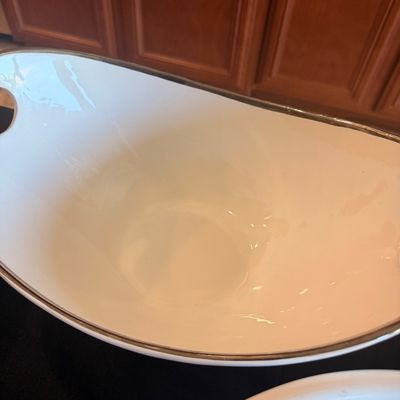 Sale Photo Thumbnail #131: Vintage white ceramic serving bowl with a silver-toned rim and integrated handles, showing a glossy finish.