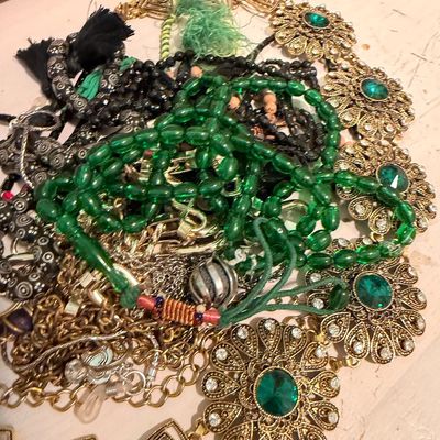 Sale Photo Thumbnail #2: Assortment of vintage costume jewelry, featuring a gold-tone filigree belt with green rhinestones, green beaded necklaces, and various chains.