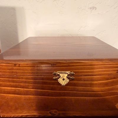 Sale Photo Thumbnail #44: Vintage wooden storage box with a polished finish and a decorative brass shell-shaped clasp.