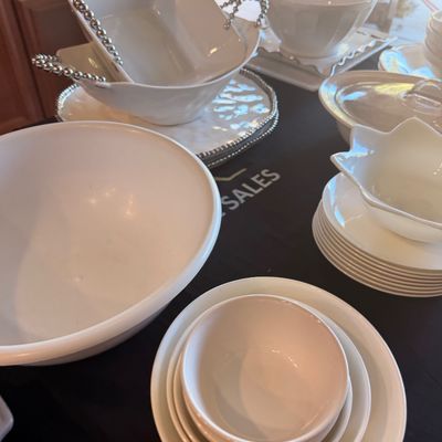 Sale Photo Thumbnail #133: Collection of white ceramic and porcelain tableware, including serving bowls with beaded metal handles, nested mixing bowls, and stacked plates.