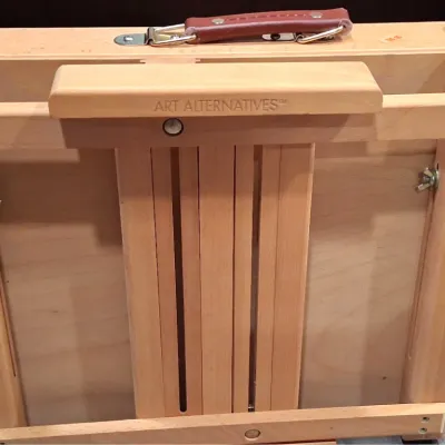 Art Alternatives wooden French companion sketchbox easel, featuring a folding design with a leatherette carrying handle and metal latches.