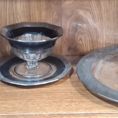 Vintage collectible shelf display featuring a cast iron building bank, a miniature brass skyscraper model, and elegant silver-rimmed...