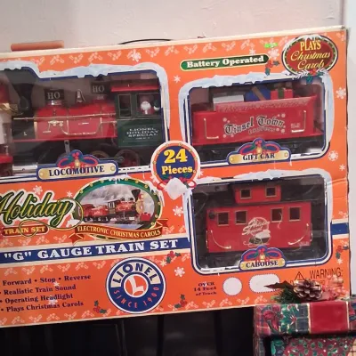 Vintage Lionel Holiday G-Gauge battery-operated train set in its original box, featuring a 24-piece set with a locomotive, gift car, and...
