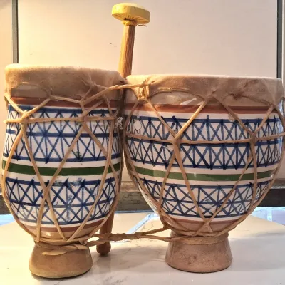 Vintage Moroccan ceramic bongo drums featuring hand-painted blue and green geometric patterns, rawhide heads, and traditional laced...
