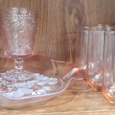 Vintage pink depression glassware collection, including a pair of Tiara 'Sandwich' pattern goblets on a matching ruffled...