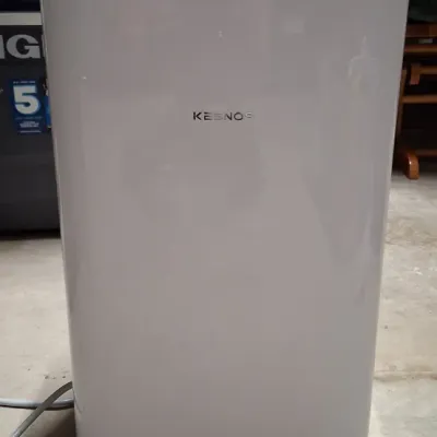 Kesnos portable dehumidifier featuring a sleek white housing with a digital control panel on top, designed for home or basement use.