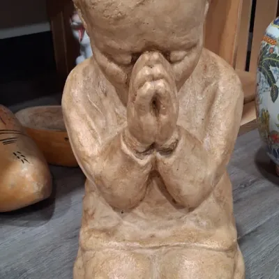 Vintage chalkware or plaster statue of a kneeling, praying boy, featuring a textured beige finish.